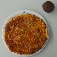 Pizza 'Pesto' mit Tomaten, Schinken und Mozzarella (2,3,19,51,74,81) + 1 Schokomuffin (15,18,19,81)