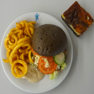 Black Teriyaki-Burger mit Pulled Pork, Eisbergsalat, Kraut, Tomate, frische Gurke und Koriander (1,2,18,21,23,26,49,51,81,83), Twister Pommes (81) + 1 Stück hausgemachten Russischen Zupfkuchen (1,15,19,81)