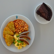 'English Breakfast' 3 Würstchen, Rührei, 3 Röstiecken und Bohnen in Tomatensoße (15,51) + 1 Stück hausgemachter veganer Schokokuchen mit Himbeeren (81)