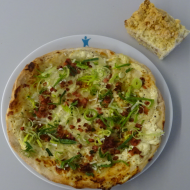 Pizza 'Elsässer Art' mit Schinkenstreifen, saurer Sahne und Speck (2,19,51,81) + 1 Stück veganer Rhabarberkuchen (81)
