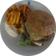 'Chris de Burger' mit Schmorkraut, Rucola, Bacon, Gewürzgurke und Bergkäse (1,2,8,9,15,19,22,44,51,52,81,82,83) dazu Twister Pommes (81)