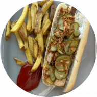 V-Hot Dog mit Räuchertofu, Gewürzgurke, Röstzwiebeln, Senf und Mayonnaise (1,2,3,9,18,21,22,81) dazu als Menüoption: verschiedene Pommes Spezialitäten