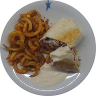 Chicken-Kebab-Wrap mit Hähnchenstreifen, Rotkohl, Weißkohl, Zwiebelringen und Kräutersoße (19,48,49,54,81) dazu Twister Pommes (81)