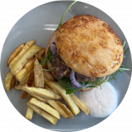 Bifteki-Burger mit Krautsalat, roten Zwiebeln und Knoblauch (19,23,49,51,52,81,83) dazu als Menüoption: verschiedene Pommes Spezialitäten