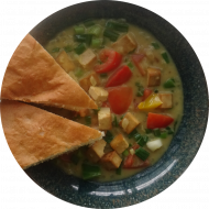 Cremiges Gemüsecurry mit Tofu, Tomaten, Paprika, Lauchzwiebeln an Mangosaft (2,3,18,49) dazu Fladenbrotecke (81,83)