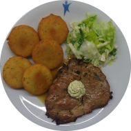 Schweinenackensteak in Bärlauch-Marinade mit Kräuterbutterrosette garniert (1,18,19,22,51,81) dazu Pfeffersoße (81) und gebackene Macairekartoffeln (81) dazu Salatgarnitur
