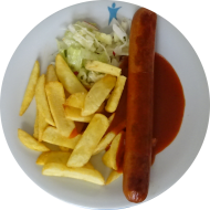 Gebratene Currywurst vom Schwein (2,3,8,51,52) mit Currysoße (81) dazu Steakhouse Pommes und Salatgarnitur