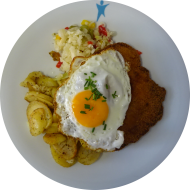 Schweineschnitzel mit Setzei (15,51,81) dazu Kräuter-Bratkartoffeln und Salatgarnitur (19)