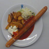 Renneressen: 'XXL Südstaaten-Currywurst' mit fruchtiger Currysoße und Limettenmayo (1,2,3,9,22,51,52) dazu Kartoffelspalten und kleiner Weißkrautsalat mit Lauchröllchen