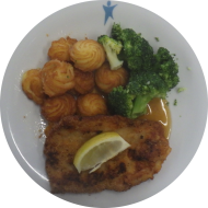 Hausgemachtes Schnitzel aus dem Schweinerücken mit Zitrone (15,81) an Bratenjus dazu Brokkoligemüse und Herzoginkartoffeln (19)