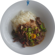 Rindfleischstreifen in Erdnusssoße mit Paprika, Frühlingslauch und Kokosmilch (2,17,18,52,62,81) dazu Glasnudeln (2,18,81)