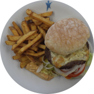 'Cheesiest Cheeseburger' mit Käseschnitzel, Onionrings, Cheddar, Eisberg, Gurke und Tomate (1,9,19,22,81,83) dazu als Menüoption Pommes und House-Dip (9,22)