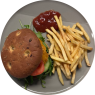  Burger Crunchy Italiano mit Cornflakespatty, Mozzarella, Rucola, Tomatendip und Zwiebeln (9,19,81,83) dazu als Menüoption Pommes und House-Dip (9,22)