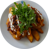 Fully Loaded Fries getoppt mit Würzfleisch vom Hähnchen (1,16,18,19,21,24,81) dazu geriebener Hartkäse (19,47) und frischem Rucola