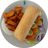 Ciabattaburger mit paniertem Seelachs, Gewürzgurke, Remoulade und roter Zwiebel (1,2,9,15,16,19,81) dazu Kartoffelspalten