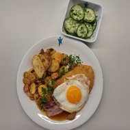 'Haufen Mist' Schweinelachsschnitzel mit Spiegelei auf Bratkartoffeln und Bacon (2,3,15,81) an Bratenjus dazu kleiner Gurkensalat mit Dill