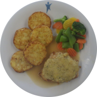 Hausgemachtes Hähnchenbrustfilet mit knuspriger Kartoffelkruste (2,3,15,24,81) an Geflügelsoße (81) dazu feine Gemüsemischung und Röstitaler