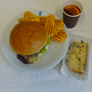 Blue Cheese Burger mit Gorgonzola, Birnen-Zwiebel-marmelade, Majonnaise, Eisbergsalat (3,9,15,19,21,22,24,52,81); Gitterkartoffelnn (81), 1 Orangenpunsch + 1 St. Landfrauenkuchen (15,19,81)
