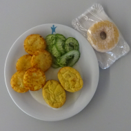 2 Brokkoli-Soufflé (15,19,81), Creme fraiche-Kräuter-Soße (19,81), Röstitaler und Gurkensalat + 1 Donut mit Puderzucker (18,19,81)